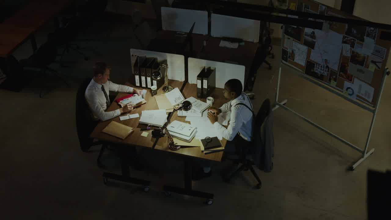 A workspace where people collaborate around a table with documents and whiteboards